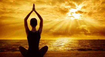 yoga-meditation-concept-woman-silhouette-healthy-meditating-pose-back-view-sun-light-rays-56996585